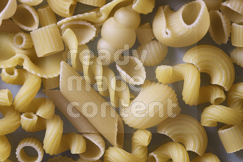 Different pasta types on light blue background