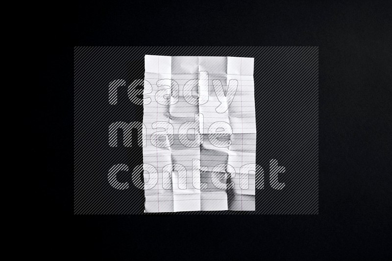 Folded notebook sheet on black background