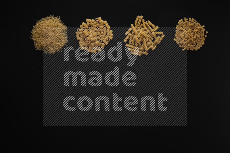 Different pasta types in 4 bunches on black background
