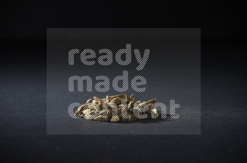 Cardamom in a circle shape on black flooring