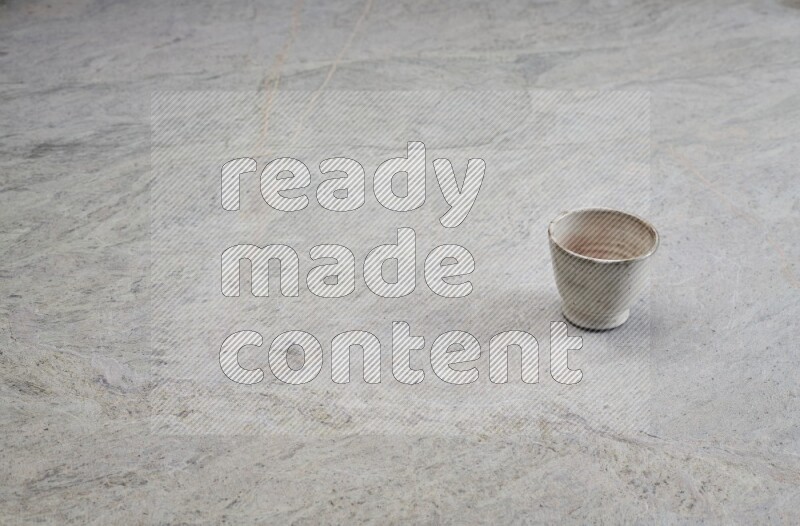 A multicolored pottery Cup on grey marble background
