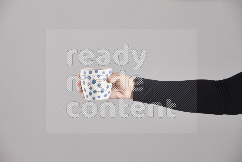 امرأة ترتدي عباءة سوداء تحمل أدوات فخارية مختلفة في أوضاع متعددة