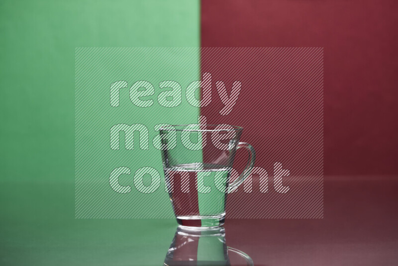 The image features a clear glassware filled with water, set against green and dark red background