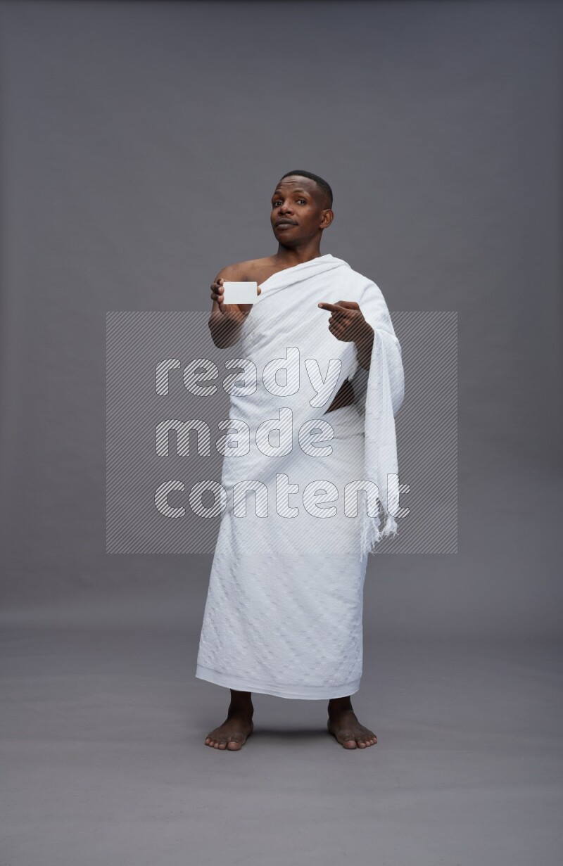 A man wearing Ehram Standing holding ATM card on gray background