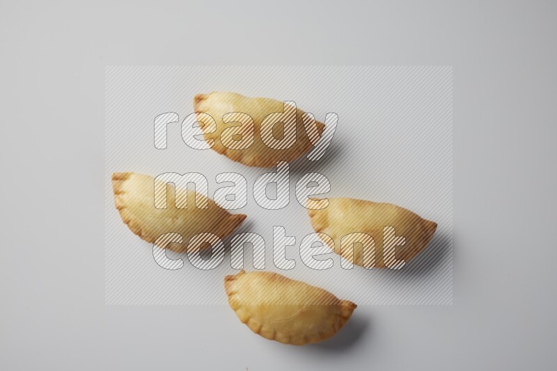 Four fried sambosa from a top angle on a white background