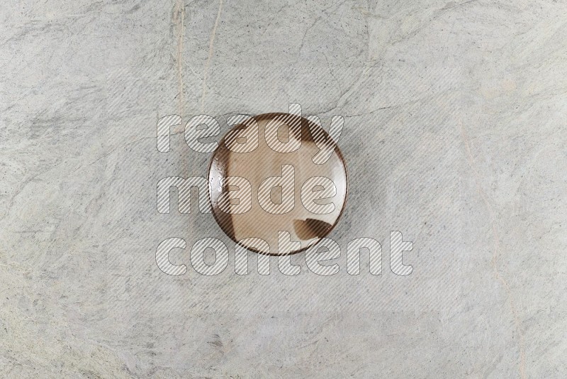 Top View Shot Of A Multicolored Pottery Plate On Grey Marble Flooring