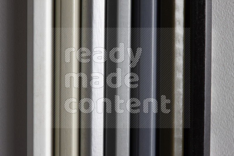 مجموعة من أقلام الرصاص الملونة مرتبة لتعرض تدرجا من اللون الأبيض والرمادي والأسود علي خلفية رمادية