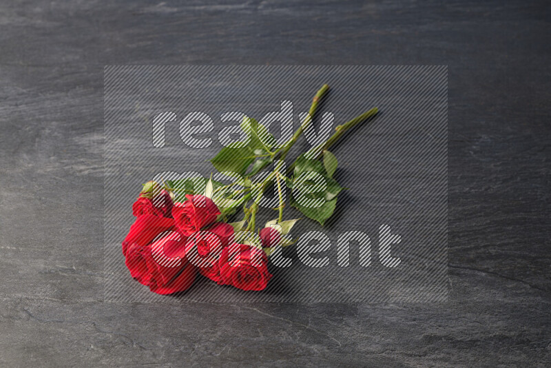 Red roses in different sizes on black marble background