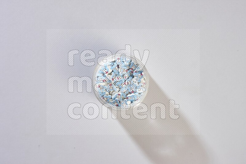 أزرار ملونة في وعاء زجاجي على خلفية رمادية