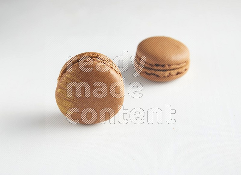 45º Shot of two Brown Coffee macarons on white background