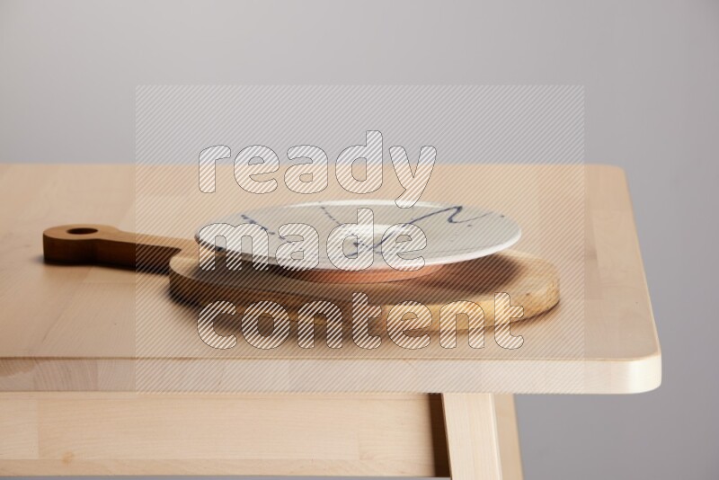 multi colored plate placed on a  wooden oval cutting board on the edge of wooden table