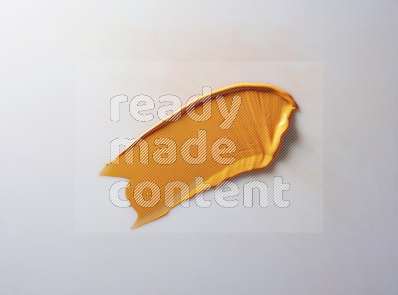 An orange single curved painting knife stroke on white background