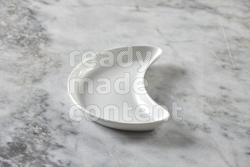 A pottery crescent plate on grey marble background