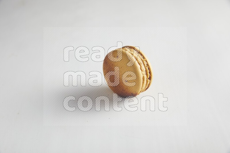 45º Shot of Yellow Crème Brulée macaron on white background