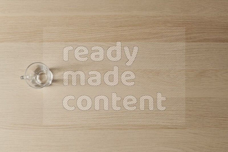 كوب زجاجي فارغ على خلفية خشبية فاتحة