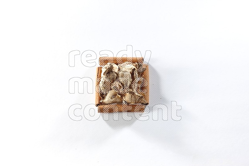 A single square of cinnamon sticks full of dried ginger on white flooring