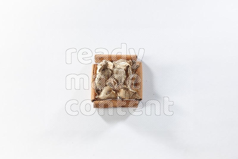 A single square of cinnamon sticks full of dried ginger on white flooring