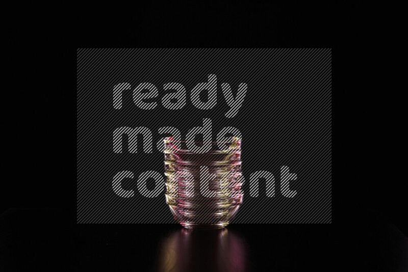 Glassware with rim light in red and yellow against black background