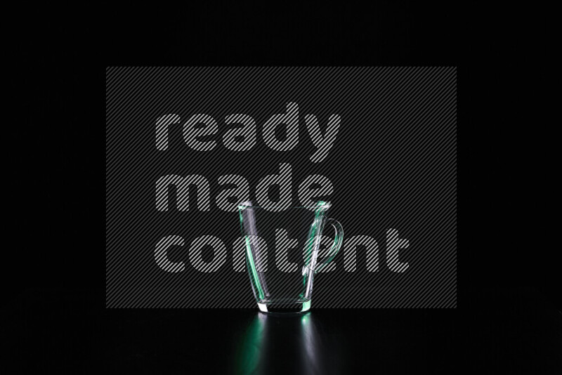 Glassware with rim light in green and white against black background