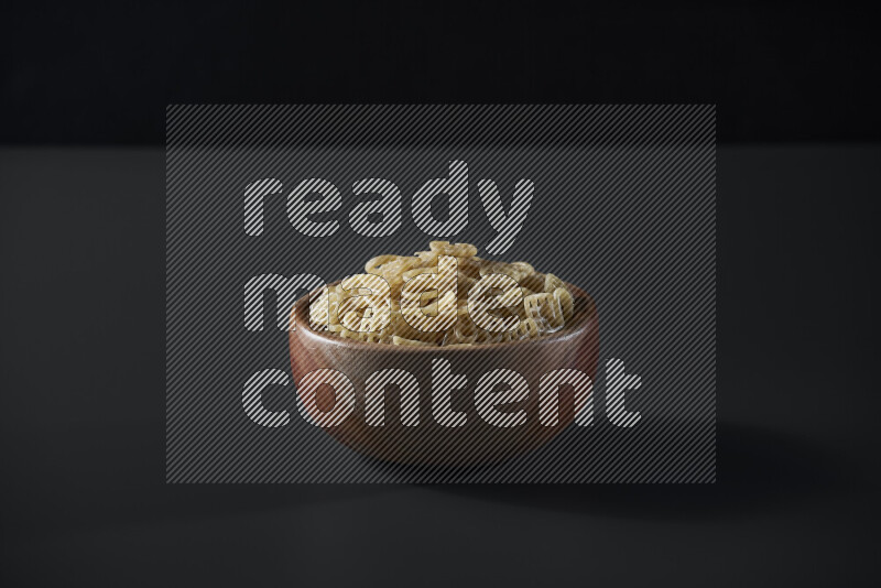 Snacks in a wooden bowl on grey background
