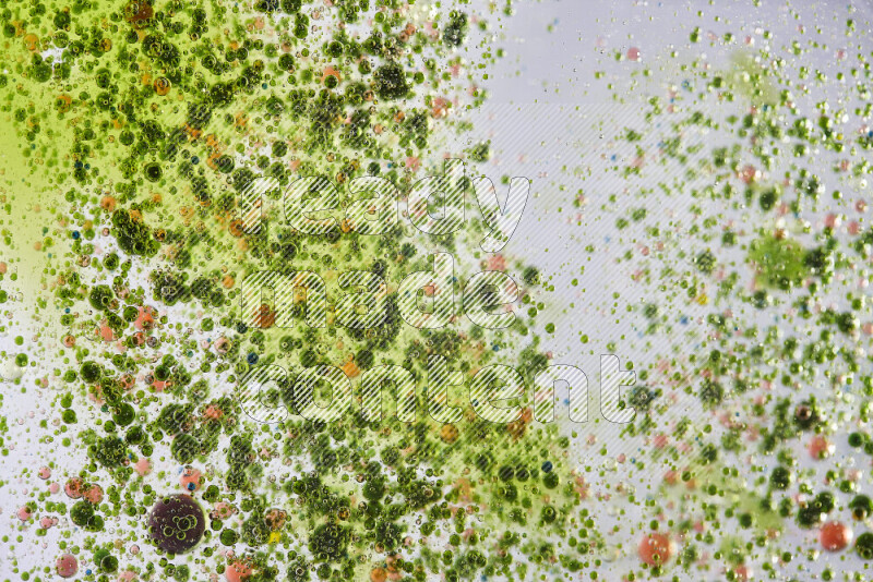 لقطات مقربة لقطرات ألوان مائية خضراء وحمراء على سطح الزيت على خلفية بيضاء