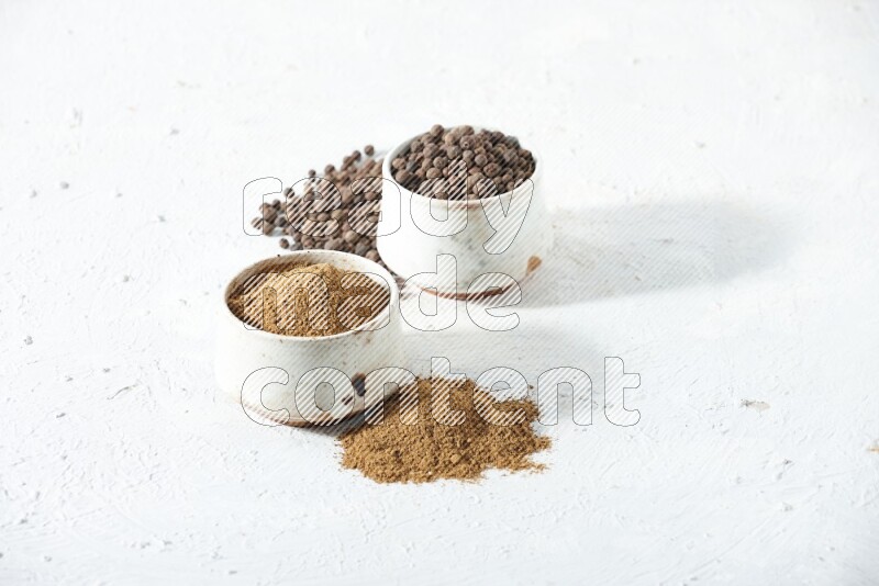 2 beige bowls, one full of powder and the other full of whole balls with balls and powder spreaded on a textured white flooring