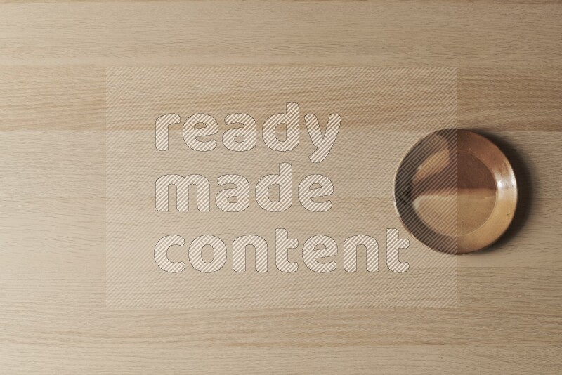 صحن فخاري متعدد الألوان على خلفية خشبية فاتحة