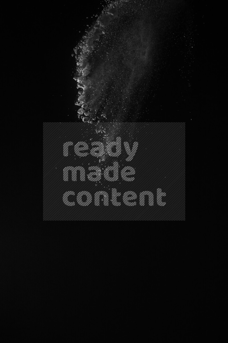 A side view of white powder explosion on black background