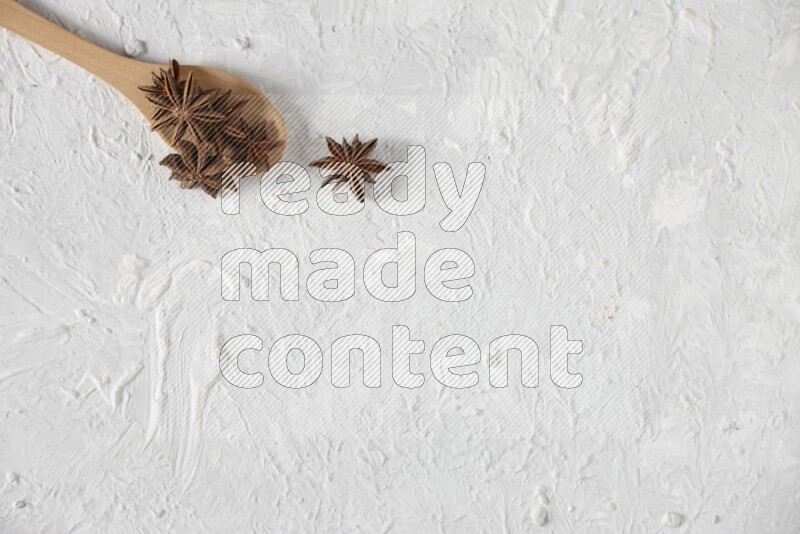 Star Anise in a wooden spoon on white flooring