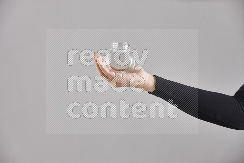 A woman in black abaya holding different glassware in different positions