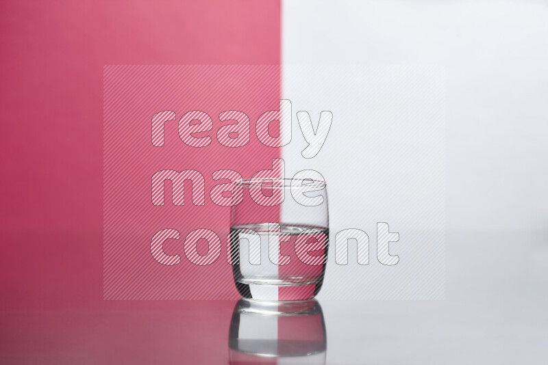 The image features a clear glassware filled with water, set against white and pink background