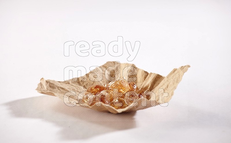A crumpled piece of paper full of gum arabic on white flooring in different angles