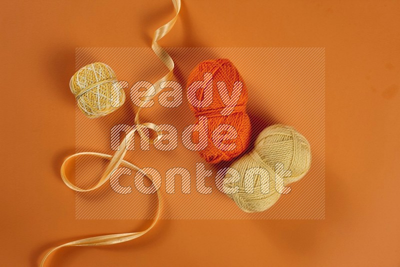 Yellow sewing supplies on orange background