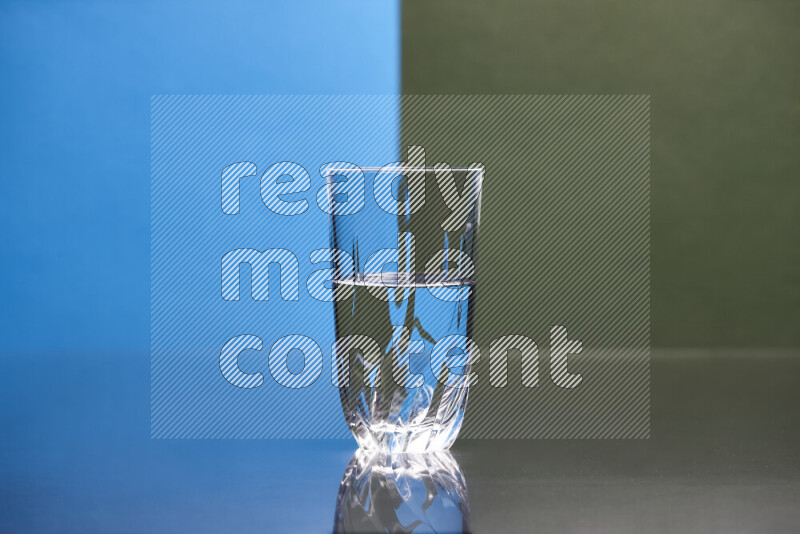 The image features a clear glassware filled with water, set against blue and dark green background