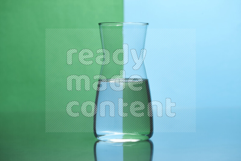 The image features a clear glassware filled with water, set against green and light blue background