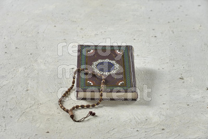 Quran with a prayer beads on white background