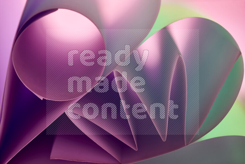 عرض فني لطيات الورق تخلق مزيج من الأشكال الهندسية، مضاءة بإضاءة ناعمة بدرجات اللون الأخضر والارجواني