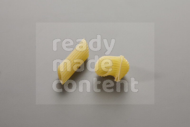 Penne pasta with other types of pasta on grey background