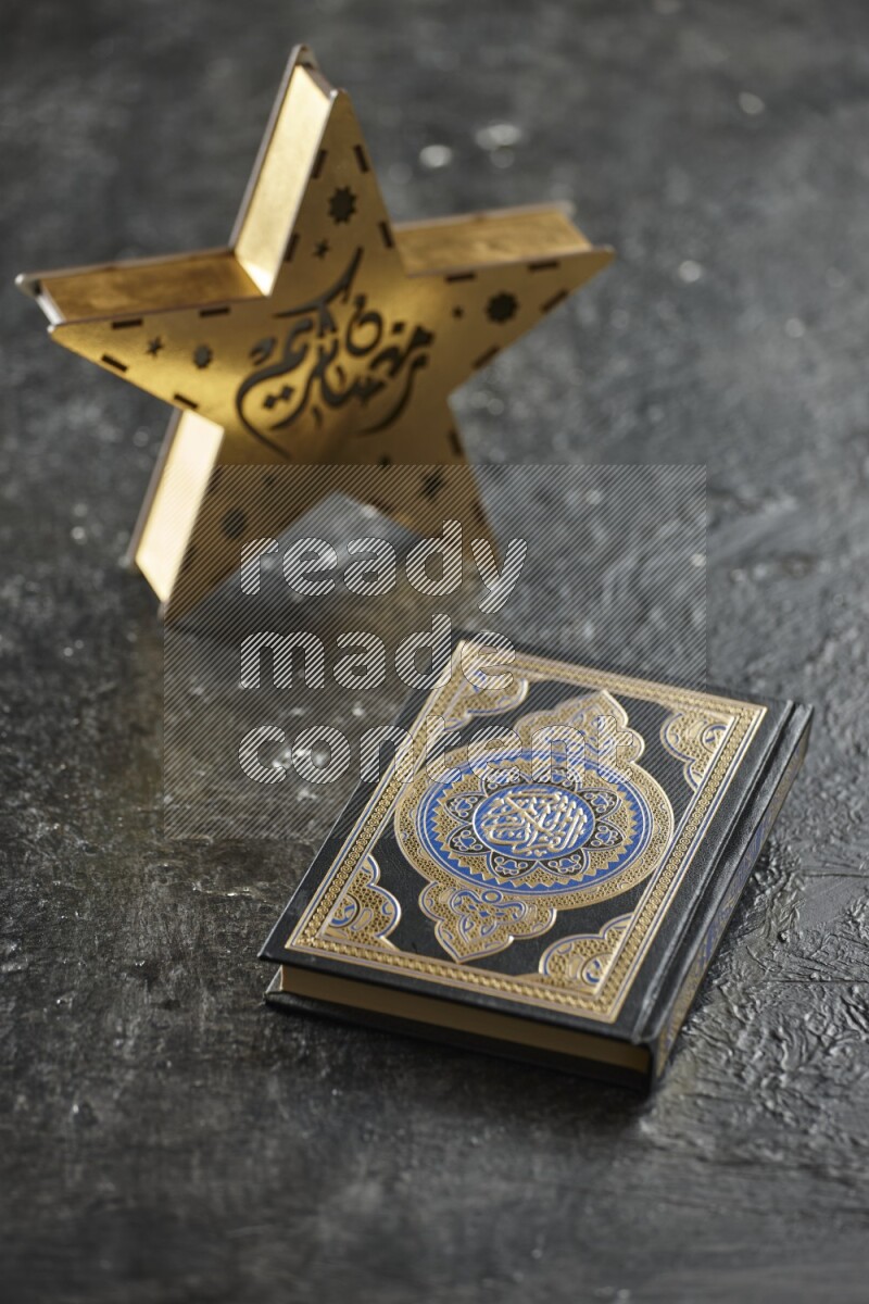 A wooden golden star lantern with different drinks, dates, nuts, prayer beads and quran on textured black background