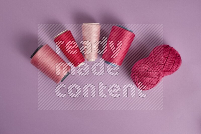 A pink and purple collection of sewing and tailoring tools arranged on a purple background