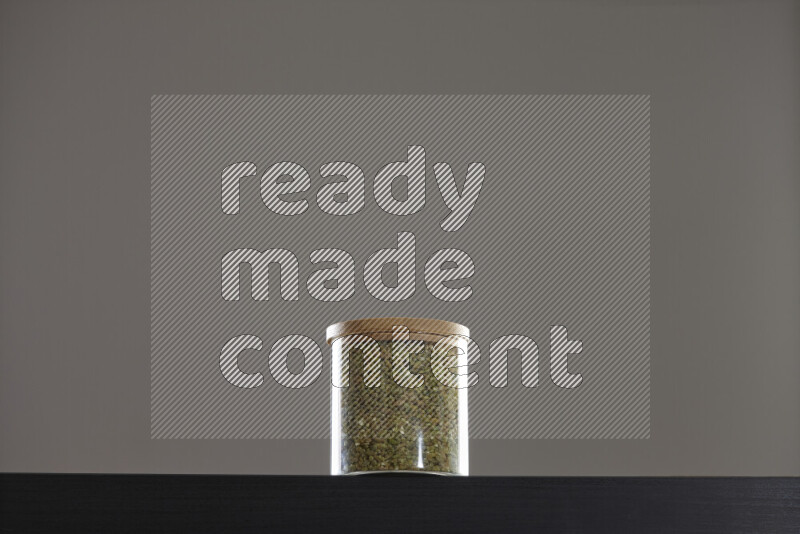 Freekeh in a glass jar on black background