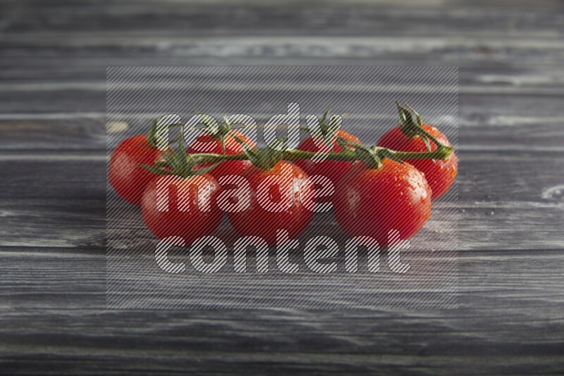 Red cherry tomato vein on a textured grey wooden background 45 degree