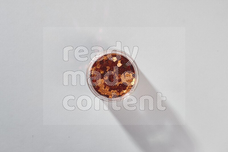 ترتر ملون في وعاء زجاجي على خلفية رمادية