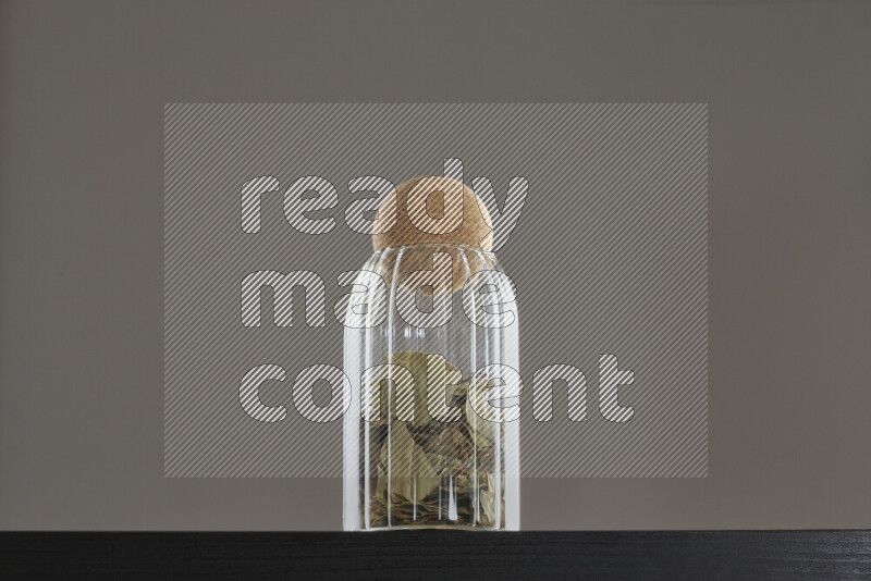 Bay laurel leaves in a glass jar on black background