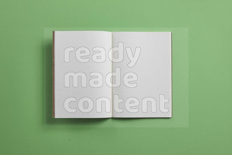 A blank open notebook on green background (back to school)
