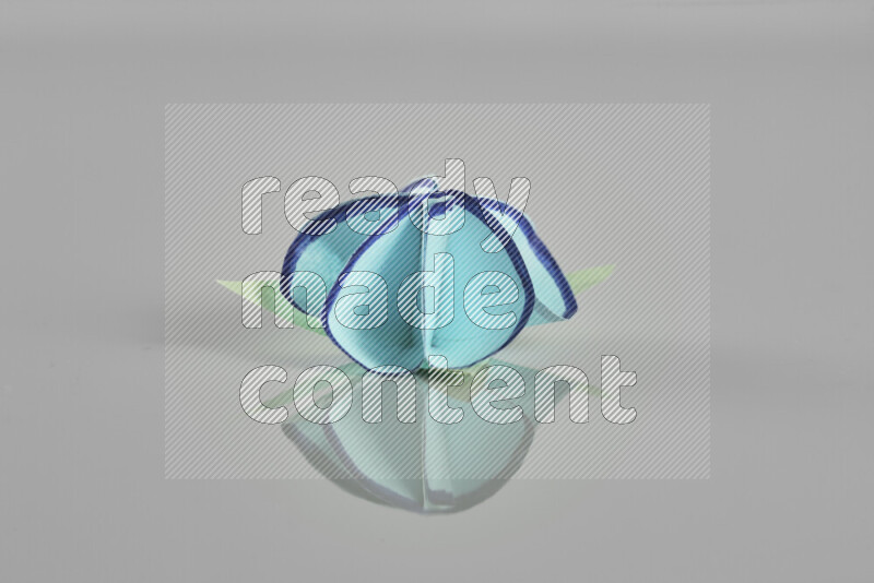 Origami flower on grey background