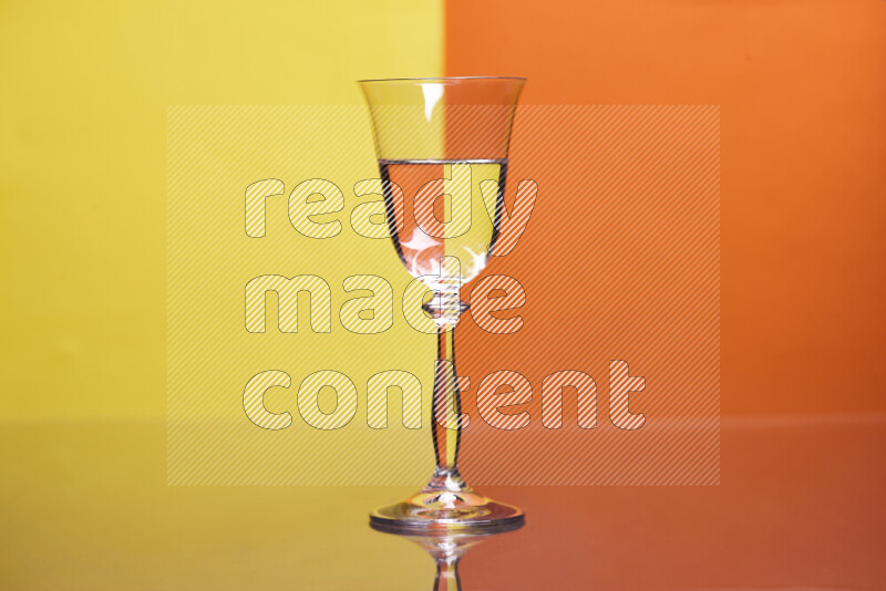 The image features a clear glassware filled with water, set against yellow and orange background