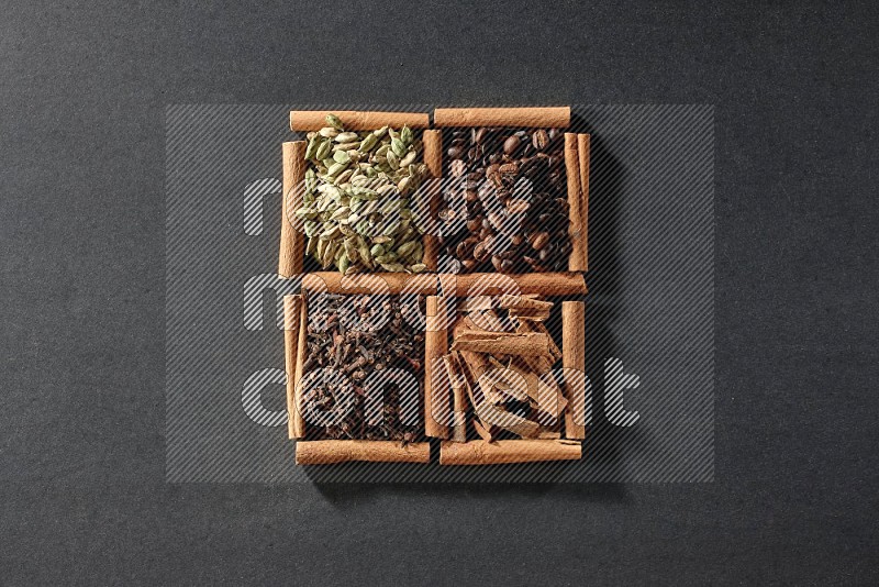 4 squares of cinnamon sticks full of coffee beans, cinnamon, cloves and cardamom on black flooring
