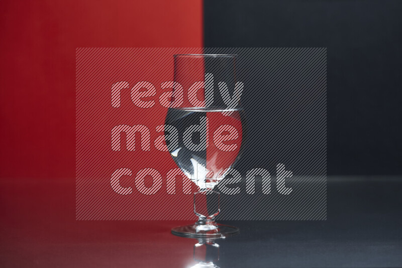 The image features a clear glassware filled with water, set against red and black background