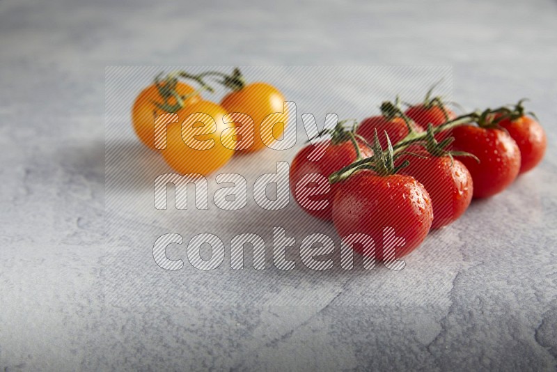Mixed cherry tomato veins on a textured light grey background 45 degree